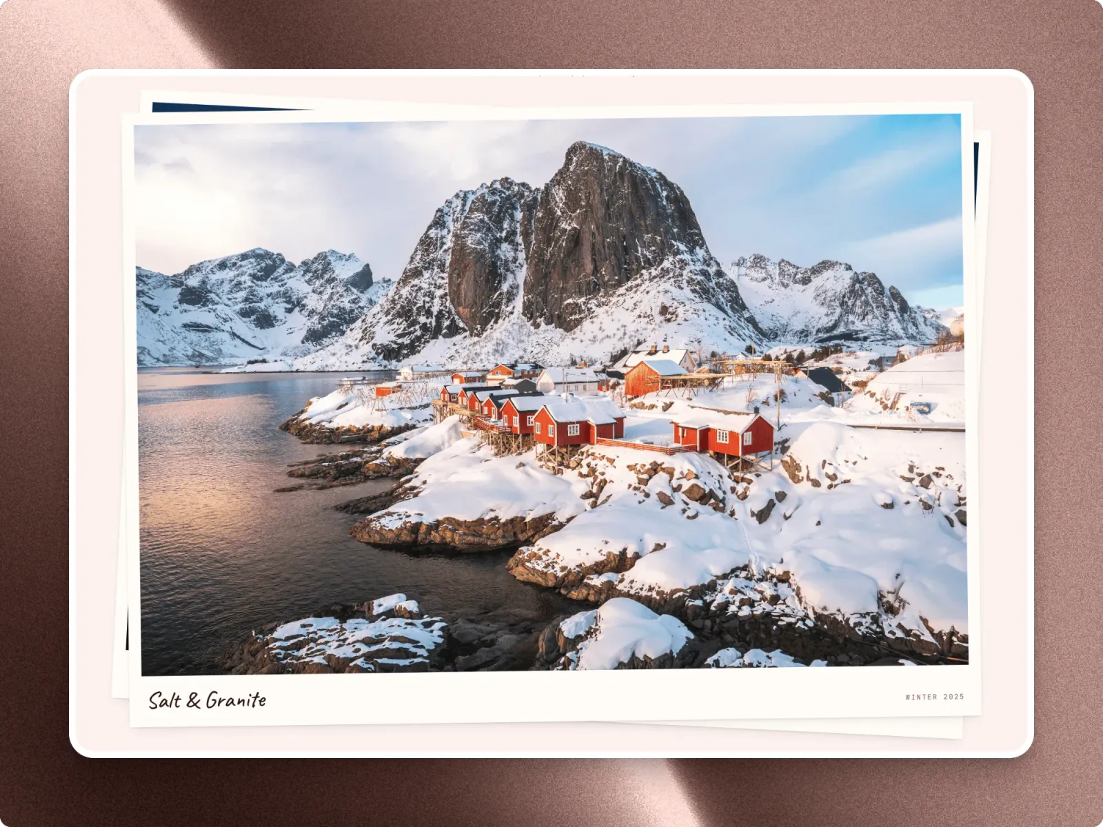 A Salt & Granite polaroid from Elias Vane: red cabins on a snowy shore below a granite peak, its title handwritten underneath